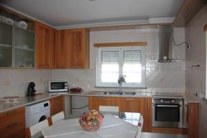 a kitchen with a table with a bowl of fruit on it at Vivenda Godinho in Nazaré
