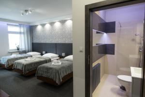 a hotel room with two beds and a bathroom at N°50 in Poznań
