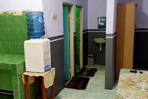 a bathroom with a blue bucket on top of a water heater at Holiday Home Anggun Bromo in Bromo
