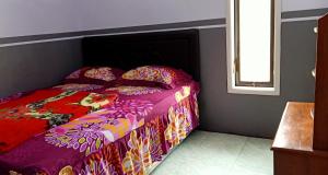 a bedroom with a bed with a colorful comforter at Holiday Home Anggun Bromo in Bromo