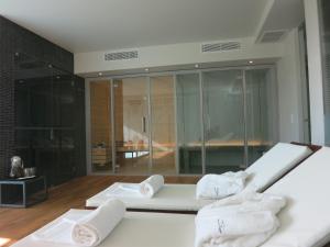a room with three towels on a bed with a glass wall at Quinta Vale da Roca in Sintra