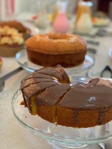 una tarta de chocolate en una bandeja de vidrio sobre una mesa en Pousada Fecho da Serra, en Capitólio