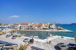 a group of cars parked in a parking lot near the water at Apartments Mira in Tribunj