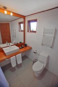 un baño con inodoro y lavabo en Hotel Puelche, en Puerto Varas 37 fotos más