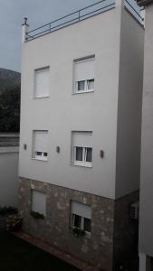 un edificio blanco con cuatro ventanas. en Hostel Hercegovina en Mostar