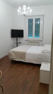 - une chambre avec un lit blanc et un lustre dans l'établissement ISONZO COMFORT APARTAMENT, à Ancône