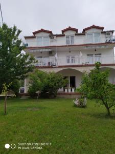 un grande edificio bianco con alberi in un cortile di Apartmant Sučić a Kaštela (Castelli)