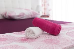 - une serviette rose et blanche sur un lit dans l'établissement Mia, à Baška Voda