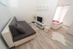 - un salon avec un canapé et une télévision dans l'établissement Mia, à Baška Voda