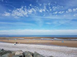 a group of people standing on a beach at Private Caravan on Golden Sands Holiday Park, North Wales in Foryd