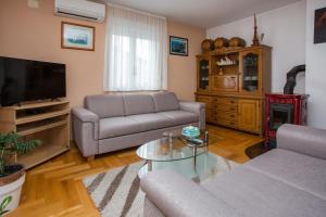 - un salon avec deux canapés et une télévision dans l'établissement Apartments Magdalena, à Stobreč