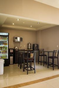 a kitchen with tables and chairs and a refrigerator at BONITTO INN® Tampico Lomas in Tampico