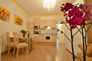 una cucina e una sala da pranzo con tavolo e fiori viola di AJO Apartments - Messe City Flat - Self-Check-in a Vienna Altre 37 foto