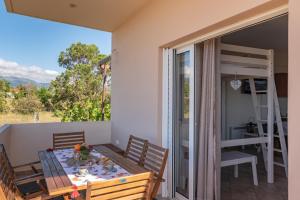 a room with a table and chairs on a balcony at Naiada Stomio-A apartment in Filiatra