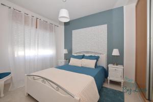 a bedroom with a bed and a blue wall at Irene's Place in Quarteira