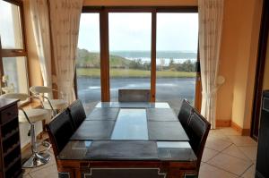 een eetkamer met een tafel en een groot raam bij No 3 Atlantic View Spanish Point in Spanish Point