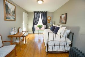 een slaapkamer met een bed, een tafel en een stoel bij Market Street Inn in Wooster +35 foto's