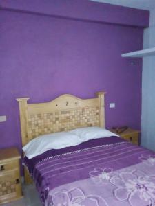 a purple bedroom with a bed with a purple wall at Altabrisa Departamento 2 habitaciones in Villahermosa