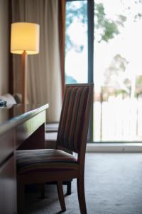 a chair sitting next to a desk in a hotel room at Yarra Valley Lodge in Wonga Park