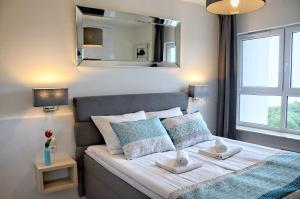 a bedroom with a bed with two towels on it at Onyx Aquamarina by Baltico Apartament in Międzyzdroje +43 photos