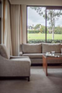 a living room with couches and a large window at Yarra Valley Lodge in Wonga Park