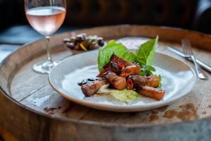 a plate of food on a table with a glass of wine at Yarra Valley Lodge in Wonga Park