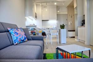 ein Wohnzimmer mit einem Sofa und einem Tisch in der Unterkunft Onyx Aquamarina by Baltico Apartament in Misdroy