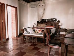 een slaapkamer met een bed, een tafel en een stoel bij Bale Asri Bukit Jimbaran in Jimbaran