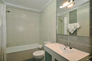 a bathroom with a sink and a toilet and a tub at Paloma Beach Apartments in Los Cristianos