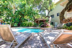 a swimming pool with two chairs and a house at Beautiful property on Siesta Key in Siesta Key