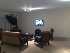 a living room with chairs and a flat screen tv at Cheerful Spacious Apartment in Rehab City , Fully Equipped, Guest First Choice & Best Offer in The City مدينة الرحاب in Cairo