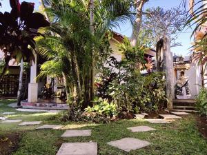 un jardín con una pasarela de piedra frente a una casa en Bale Asri Bukit Jimbaran, en Jimbaran