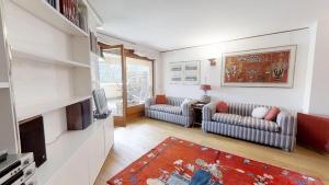 a living room with two couches and a tv at Caspar Badrutt - St. Moritz in St. Moritz