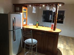 eine Küche mit einem Kühlschrank und einer Theke mit einer Bar in der Unterkunft Bellísimo Departamento in Mariano J. Haedo