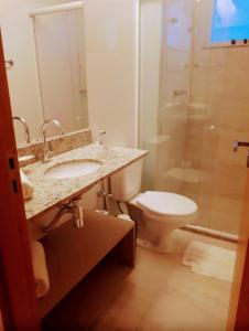 ein Bad mit einem WC, einem Waschbecken und einer Dusche in der Unterkunft Salinas Park Resort 2 Quartos in Salinópolis