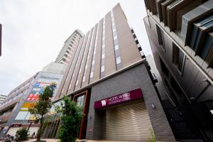 a building with a sign on the side of it at Hotel Wing International Kobe - Shinnagata Ekimae in Kobe