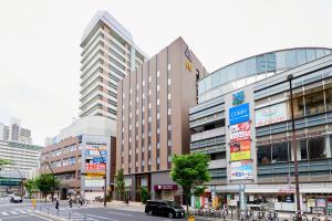 a group of buildings in a city with a street at Hotel Wing International Kobe - Shinnagata Ekimae in Kobe