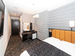a hotel room with a bed and a desk at APA Hotel Himeji-Eki-Kita in Himeji