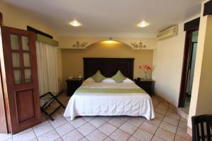 
a bedroom with a bed and a dresser at Hotel CasAntica in Oaxaca City
