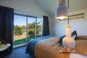 a bedroom with a bed and a large window at The Arrow Nest in Arrowtown