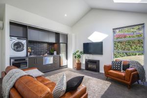 a living room with a couch and a tv at The Arrow Nest in Arrowtown