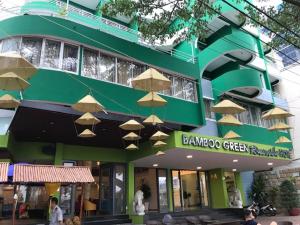a green building with umbrellas in front of it at Bamboo Green Riverside Hotel in Danang