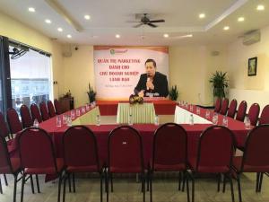 a meeting room with a long table with red chairs at Bamboo Green Riverside Hotel in Danang