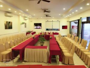 una gran sala de conferencias con mesas y sillas rojas en Bamboo Green Riverside Hotel, en Da Nang
