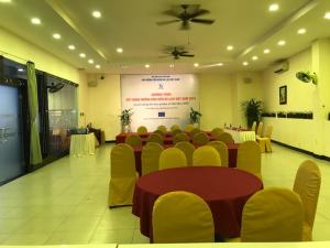 a conference room with a table and chairs and a screen at Bamboo Green Riverside Hotel in Danang