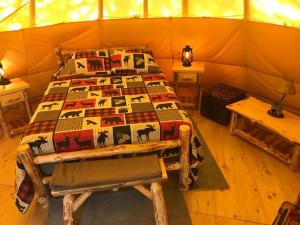 - une chambre avec un lit dans une tente dans l'établissement Eycat Lodging Company, à Wapiti