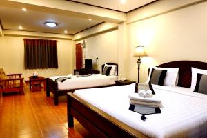 una camera d'albergo con due letti e una sedia di NanBaanKhun Hotel a Nan