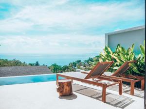 a pair of chairs sitting on the edge of a pool at Mayara pool villas in Haad Yao