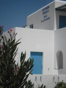 a white building with a sign on it at Studios Parian Blu in Logaras