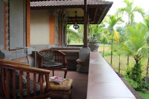 - une terrasse couverte avec 2 chaises et une fenêtre dans l'établissement Bella Villas, à Ubud